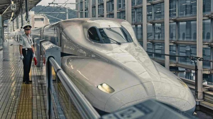 Train de passagers blanc brillant en gare, voyageur sur le quai