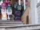 Un chat se repose sur des escaliers à côté de caisses empilées colorées